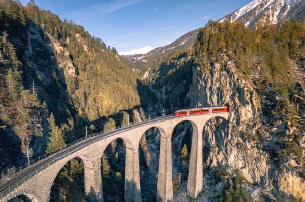 A train passing along the famous Landwasser railway, famous for the viaduct and beautiful scenery surrounding the railway in the Switzerland mountains